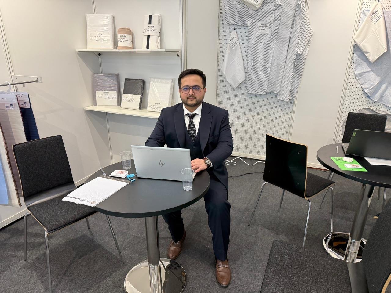 Multifabric Pakistan representative seated at the exhibition stand with textile samples